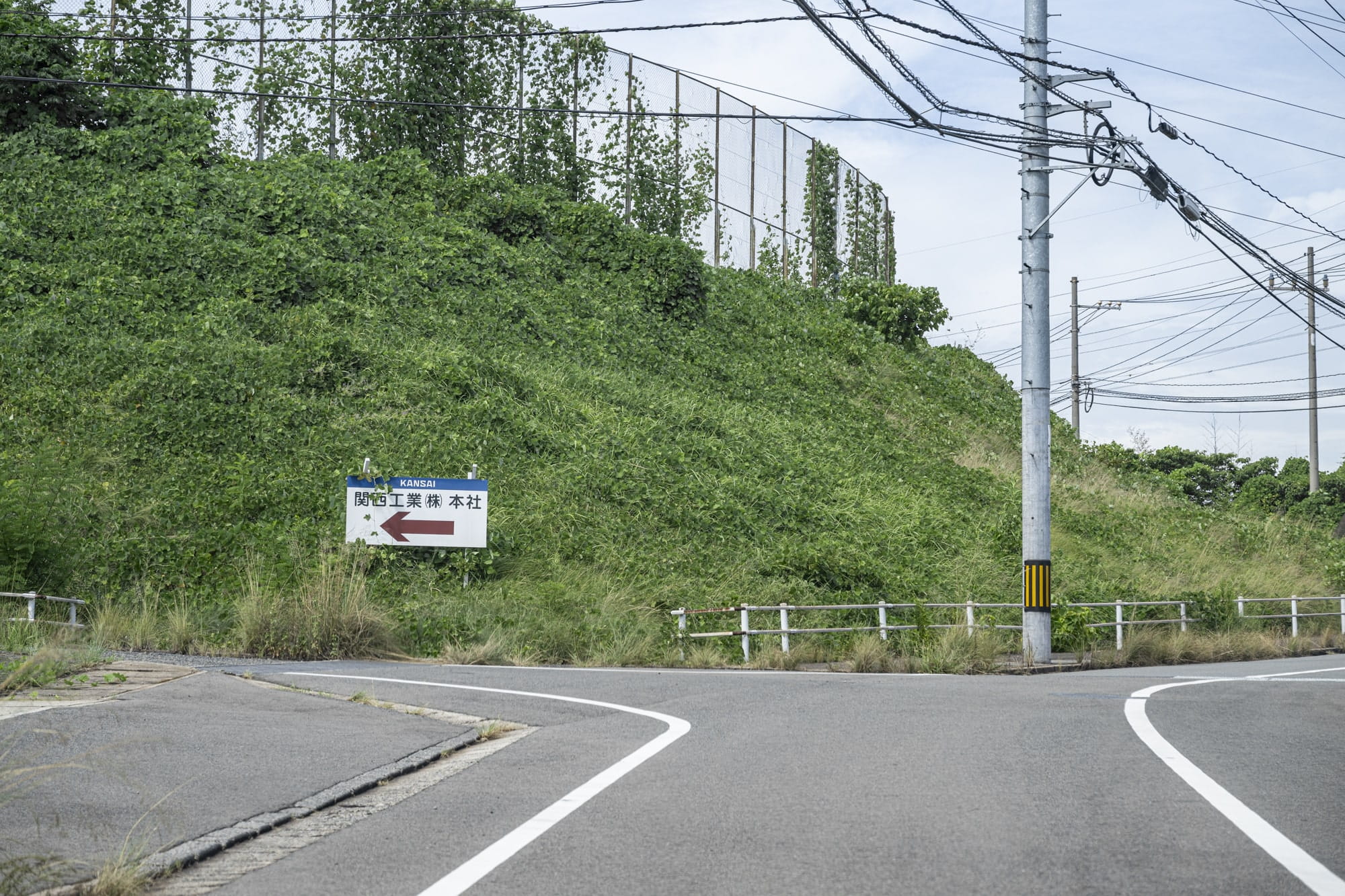 2)看板が見えてきますので、看板のある三差路を左折し直進してください。